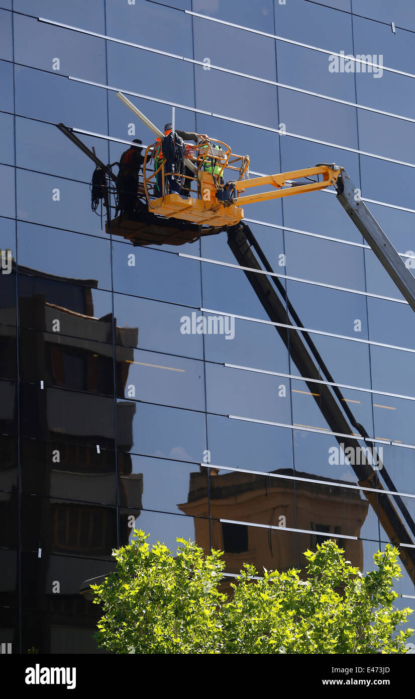 Ein Fenster Reinigung team gesehen arbeiten über unteren Ebenen auf einem Wolkenkratzer in Mallorca Stockfoto