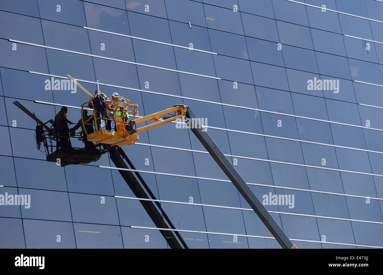 Ein Fenster Reinigung team gesehen arbeiten über unteren Ebenen auf einem Wolkenkratzer in Mallorca Stockfoto