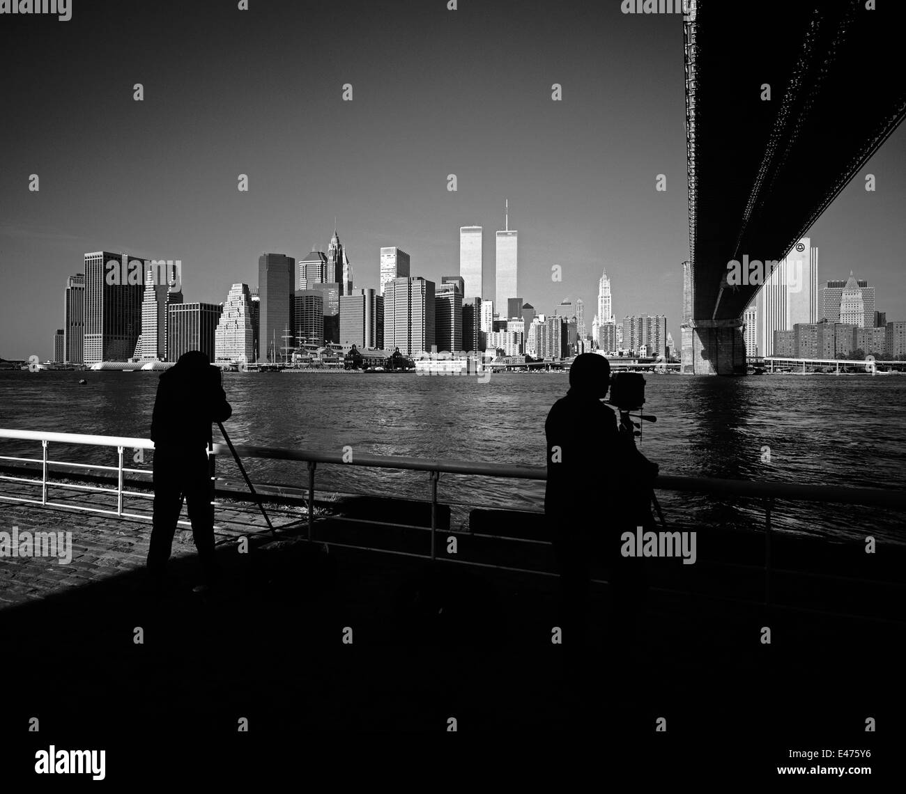 Silhouetten von Fotografen, die vor dem 11 2001. September in New York City NY USA Fotos von der Skyline von Lower Manhattan mit der Brooklyn Bridge, East River, gemacht haben Stockfoto