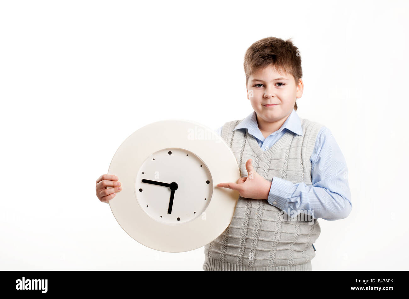 junge Kind Uhr Schüler Hintergrundbeleuchtung Hände einmal weißen Hemd Weste Form blond Schule zeigt halten rund 8 Jahre halten Sie Lächeln Stockfoto