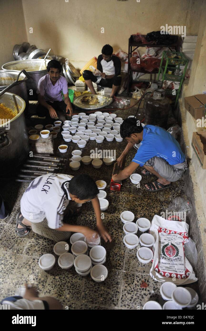 (140704)--SANAA, 4. Juli 2014 (Xinhua)--jemenitische Männer bereiten Mahlzeiten zu den armen Leuten in Sanaa, Jemen, 4. Juli 2014 verteilt werden. Während des Heiligen Monats Ramadan Muslime Nächstenliebe zu geben, zum Beispiel freie Kost, zu den armen Leuten, die ihre Familien zu den Mahlzeiten nicht liefern können. (Xinhua/Mohammed Mohammed) Stockfoto