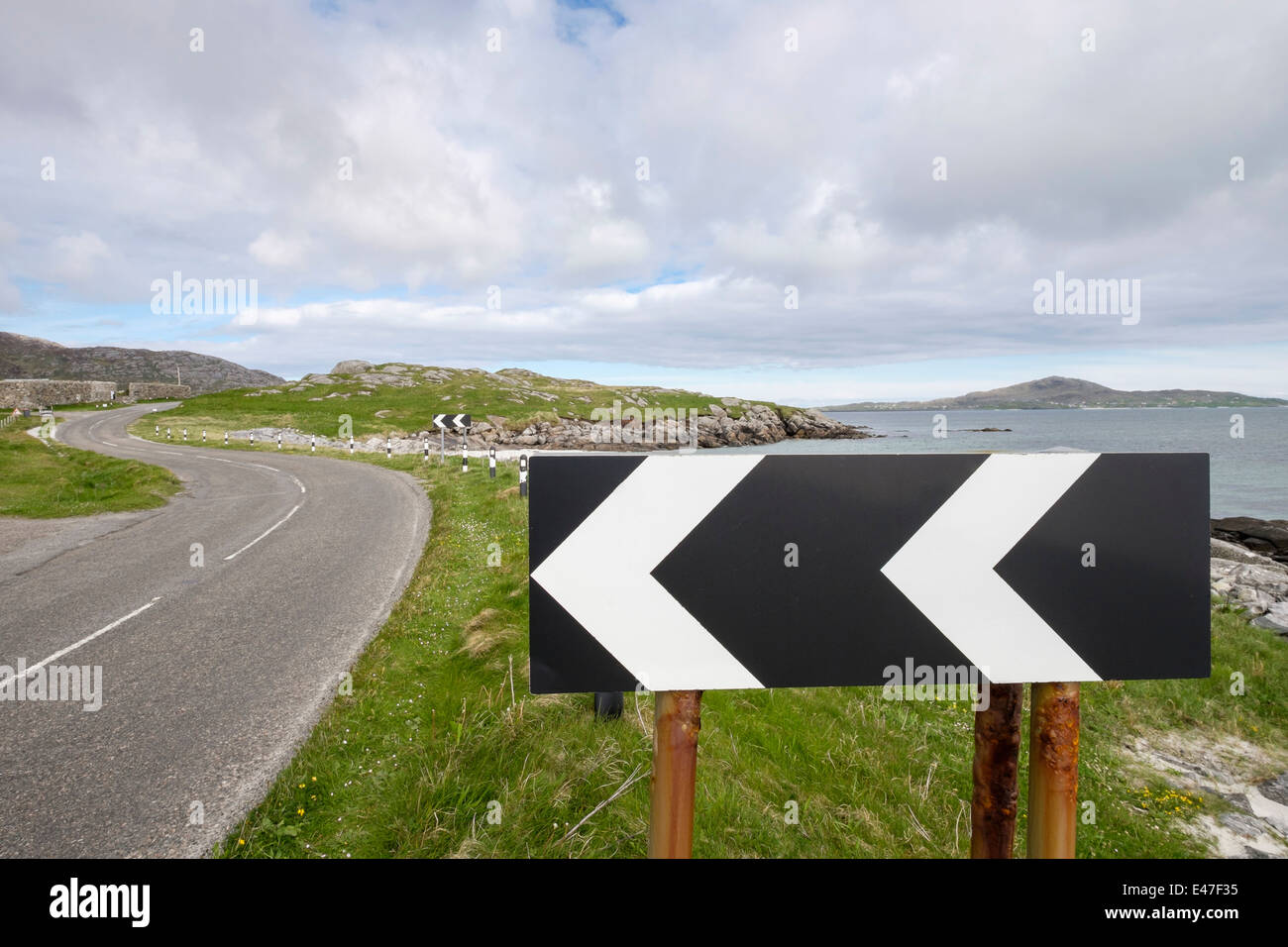 Schwarze und weiße Chevron Zeichen Warnung scharfe Lefthand auf einer Küstenstraße auf South Uist Äußere Hebriden Western Isles Schottland Großbritannien beugen Stockfoto