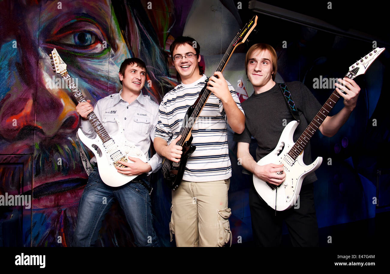 Drei Rock-Gitarristen Scherz, lächelnd und fröhlich Musizieren Stockfoto