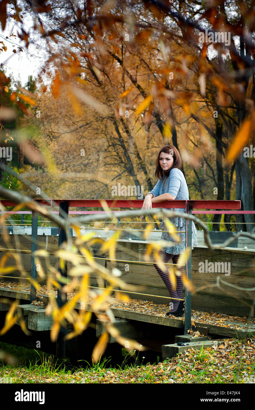 Hübsches Mädchen steht auf der Brücke. Herbst Stockfoto