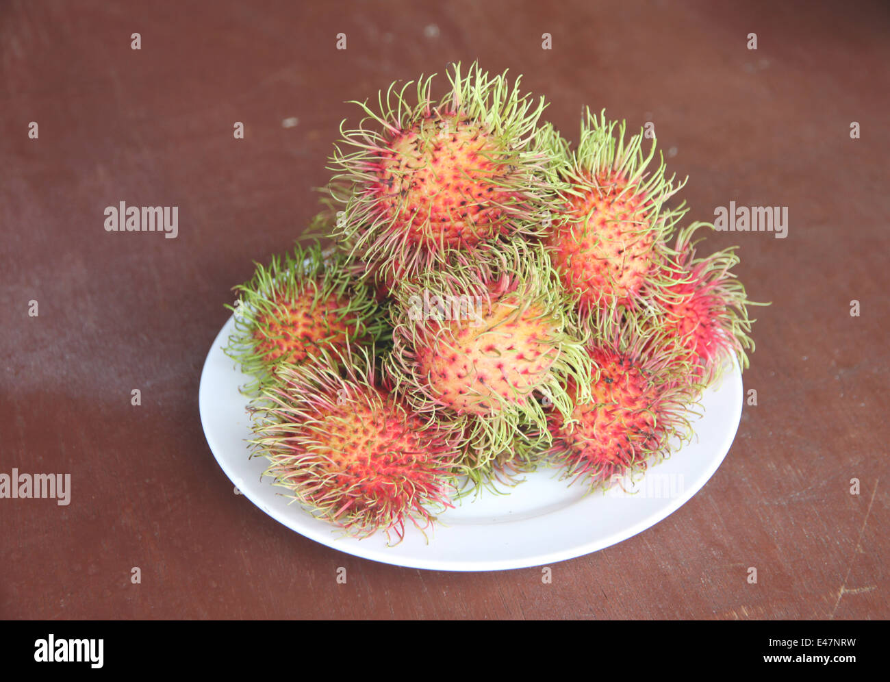 Frische Rambutan Früchte in Schale auf der Lebensmittel-Tabelle. Stockfoto
