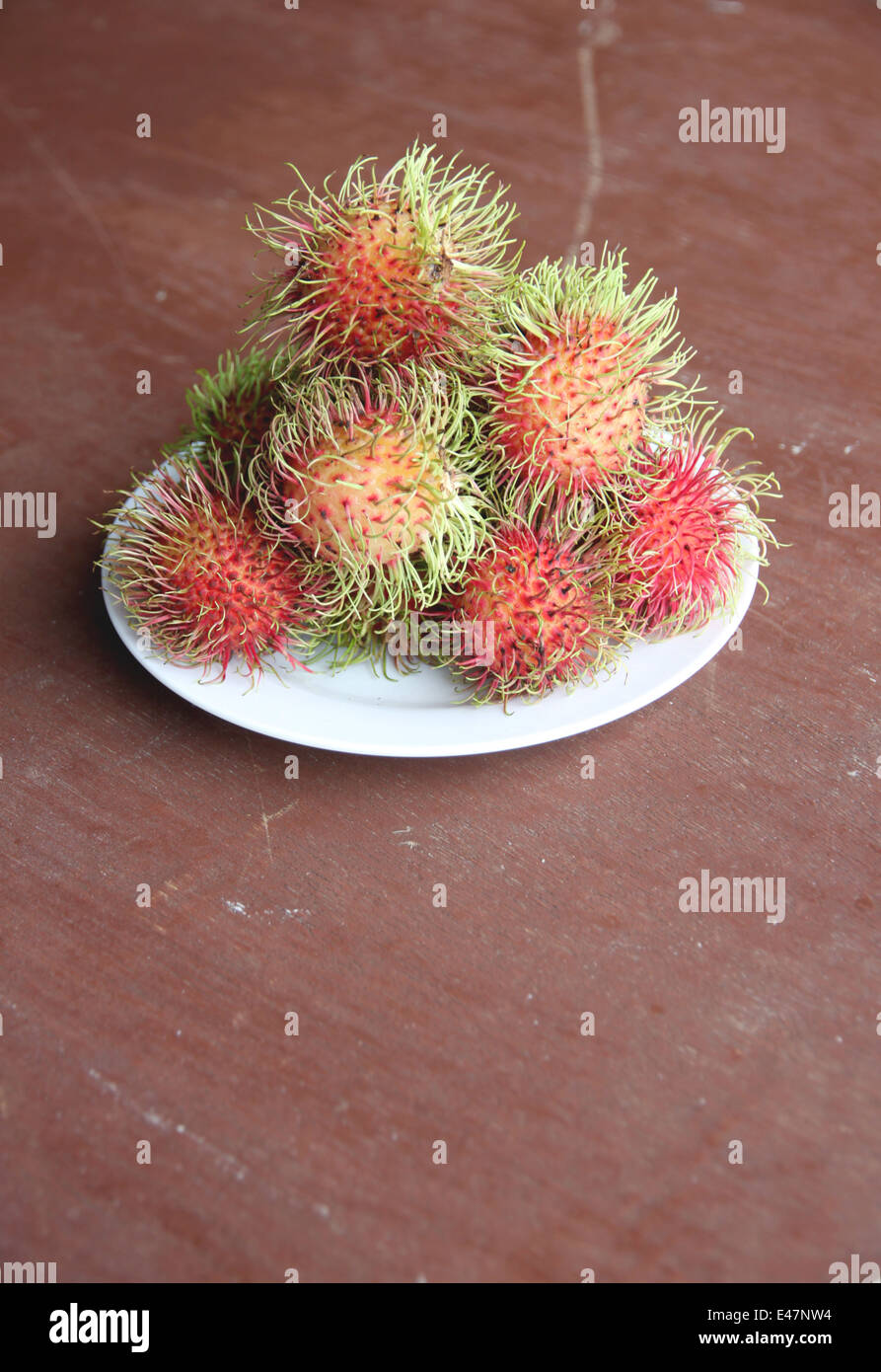 Frische Rambutan Früchte in Schale auf der Lebensmittel-Tabelle. Stockfoto