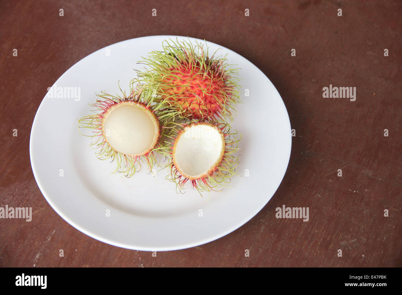 Frische Rambutan Früchte schälen in Schale auf der Lebensmittel-Tabelle. Stockfoto