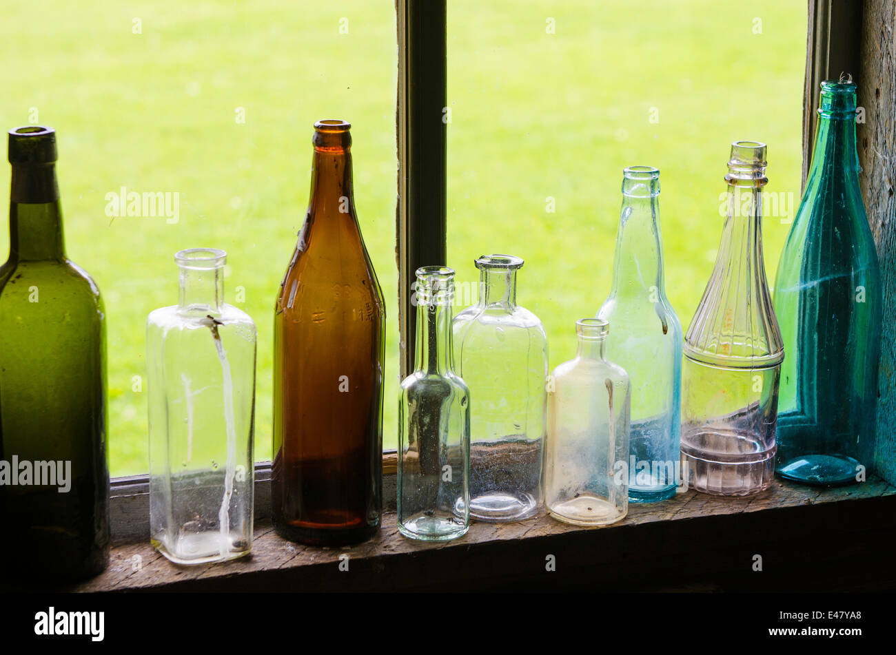 Antike Glasflaschen in Kabinenfenster im Heritage Park Museum, Terrasse, British Columbia, Kanada. Stockfoto