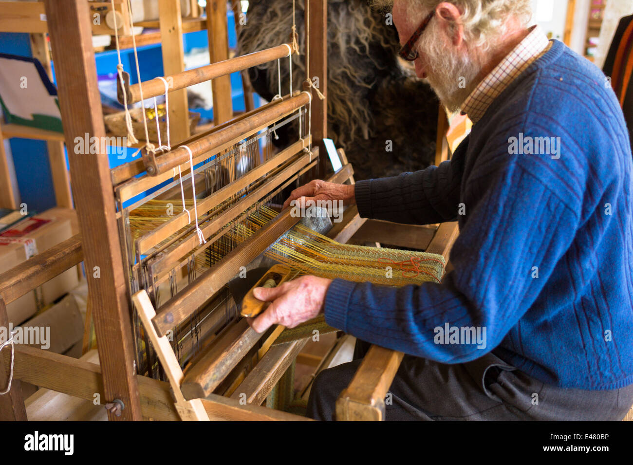 Handwerker mit traditionellen Webstuhl zum Weben Wolle für handgefertigte Wolle Schal in Croft Wolle Weber in den Highlands von Schottland Stockfoto