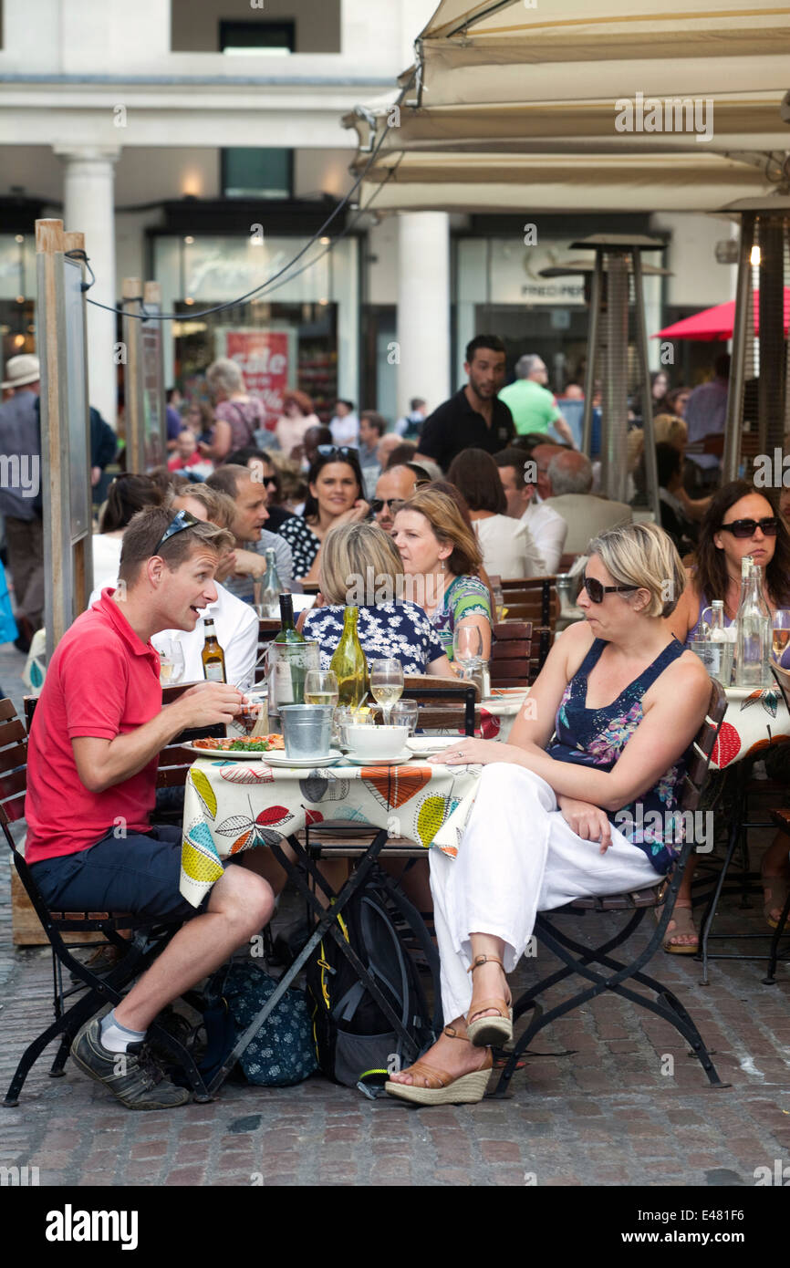 Ein Mann und eine Frau zu sprechen, an einem Tisch für draußen in einem Restaurant in Covent Garden Market, London, UK Stockfoto