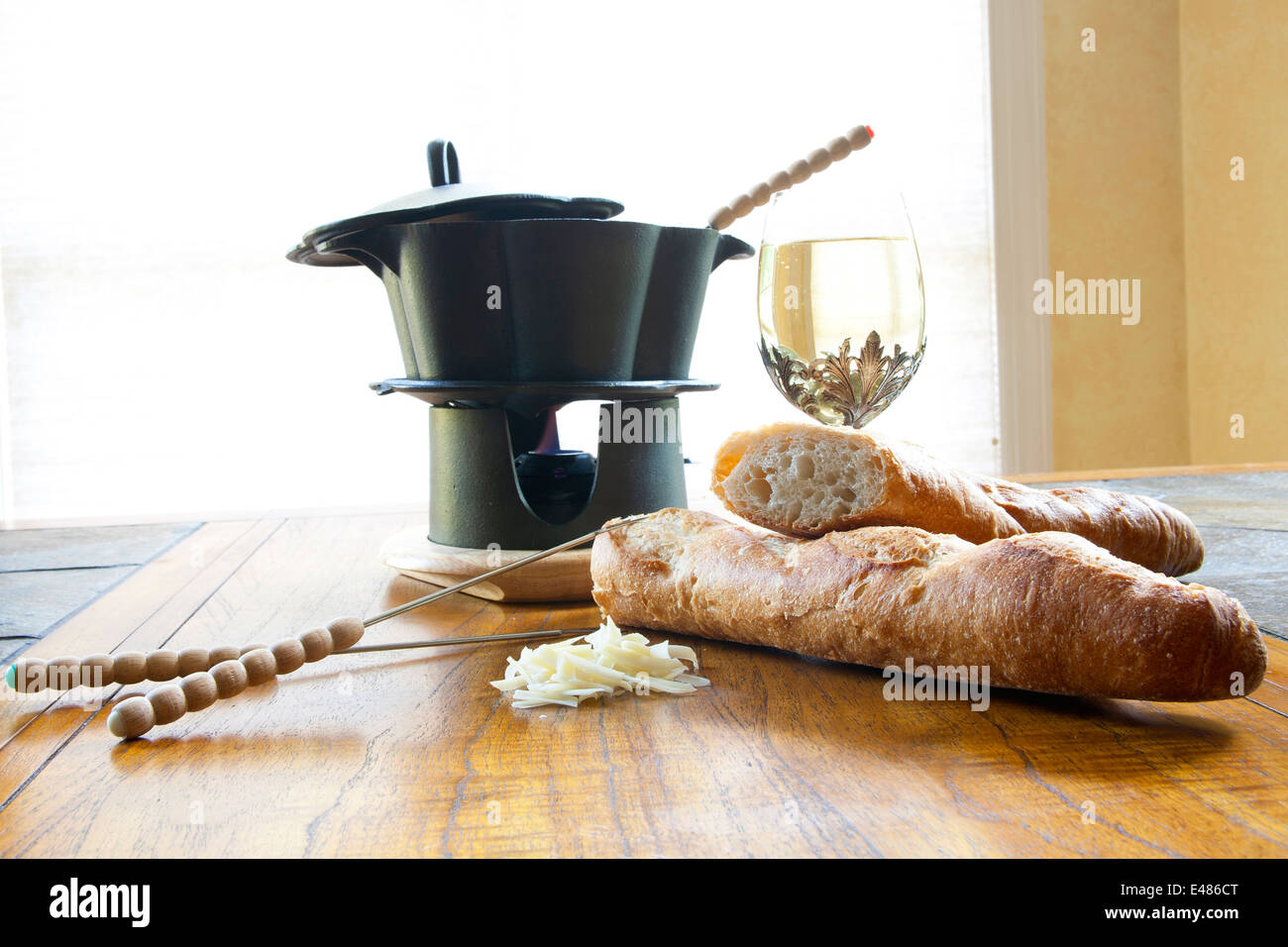 Stillleben-Anordnung der Fondue-Topf mit Spießen, knuspriges Brot, Käse und Wein. Stockfoto