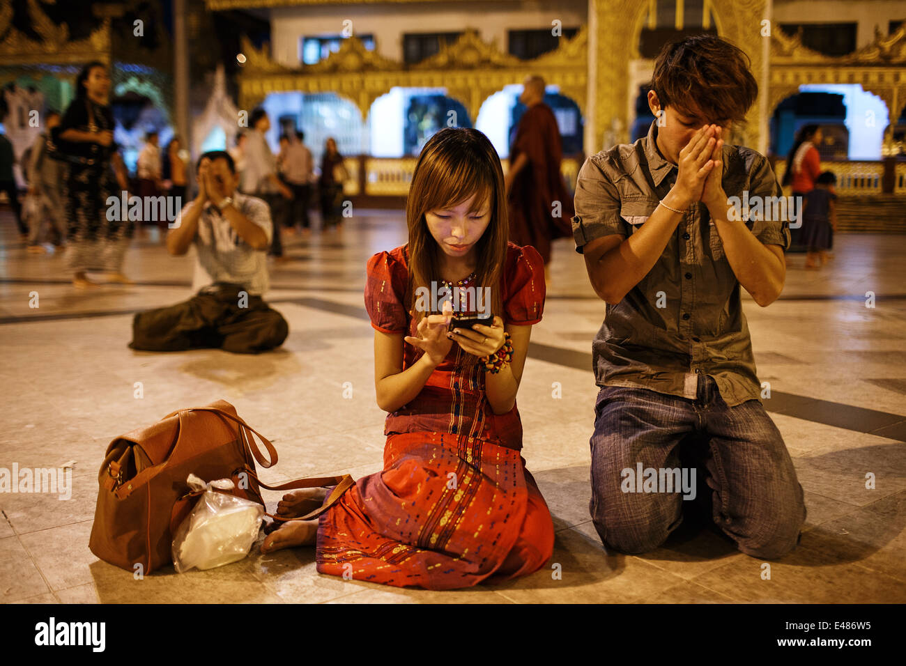 Ein junges Paar an der Shwedagon-Pagode in Yangon, Myanmar Birma beten Stockfoto