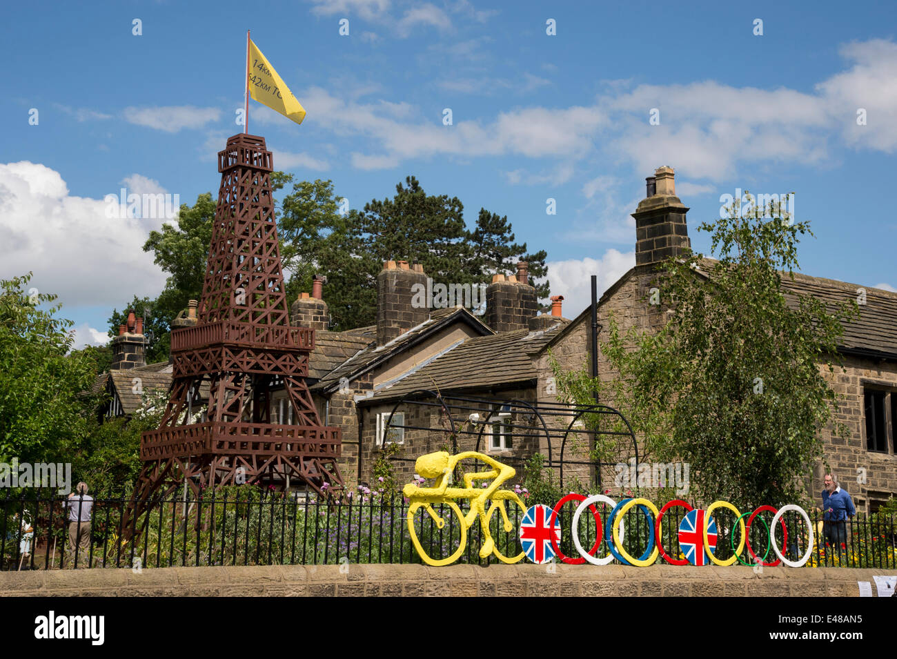 Beeindruckende Holz- Eiffelturm Modell Le Tour in Yorkshire zu feiern, ist zentrales Merkmal der privaten Garten, von Menschen beim Tag der offenen Tür gesehen, Geld für die lokale Nächstenliebe (Scout & Guide Gruppe zu erhöhen. Gelb Modell der Radfahrer ist mit Geländer außen eingehängt. - Burley-In - Wharfedale, England, UK. Stockfoto