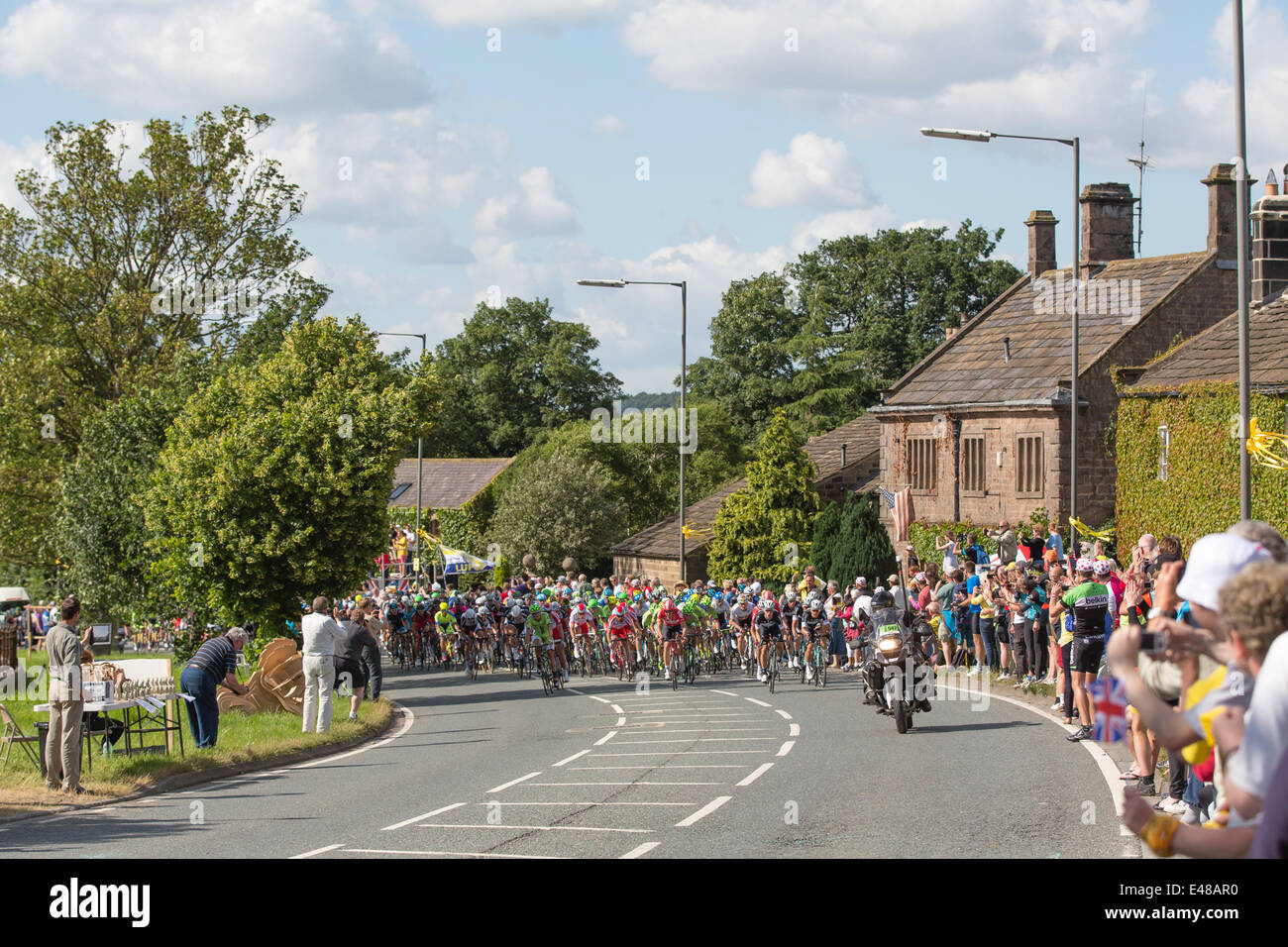 Harrogate, Nordyorkshire. 5. Juli 2014. Ein dicht gepackten Hauptfeld betritt Yorkshire Dorf von Killinghall, 3 Meilen vom den ersten Tag beenden in Harrogate. Copyright Ian Wray/Alamy Live-Nachrichten Stockfoto