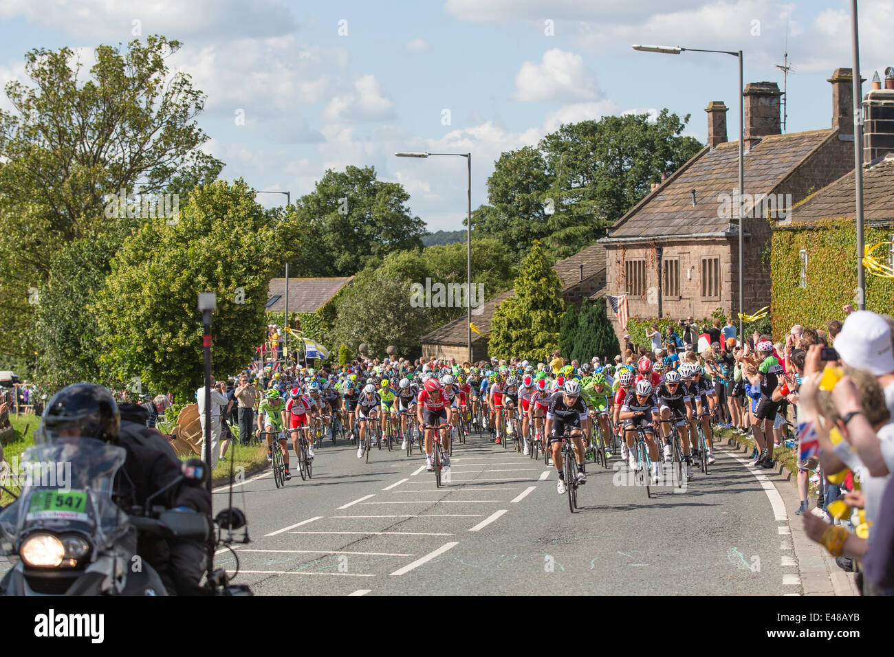 Harrogate, Nordyorkshire. 5. Juli 2014. Ein dicht gepackten Hauptfeld betritt Yorkshire Dorf von Killinghall, 3 Meilen vom den ersten Tag beenden in Harrogate. Copyright Ian Wray/Alamy Live-Nachrichten Stockfoto