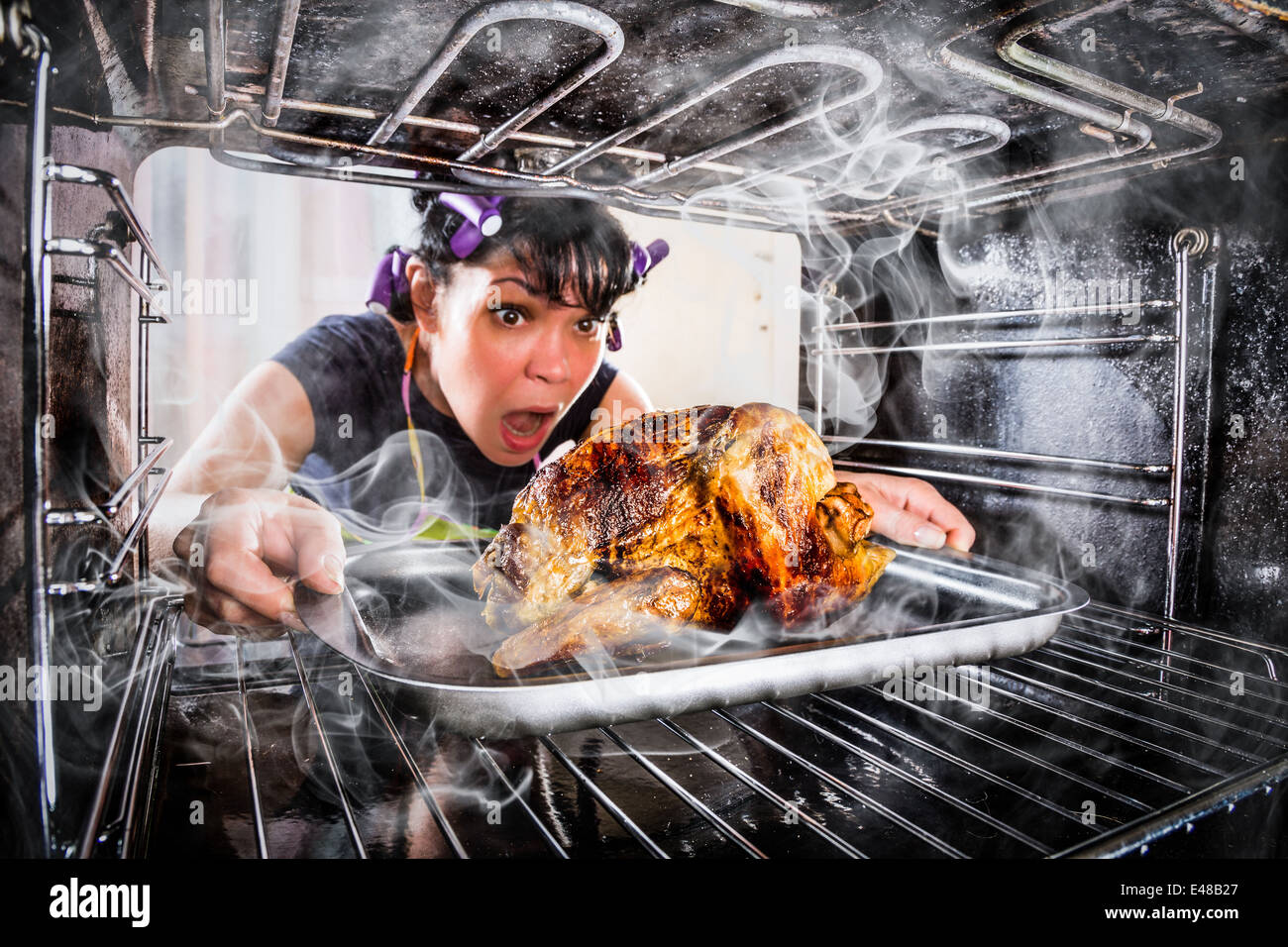 Hausfrau bereitet gebratenes Huhn in den Ofen, Blick aus dem Inneren des Ofens. Kochen in den Ofen. Stockfoto