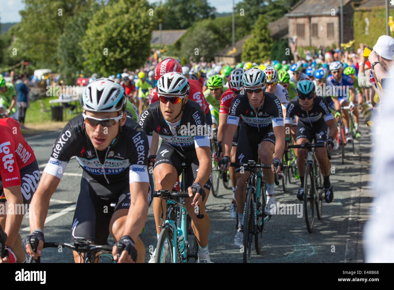 Harrogate, Nordyorkshire. 5. Juli 2014. Ein dicht gepackten Hauptfeld betritt Yorkshire Dorf von Killinghall, 3 Meilen vom den ersten Tag beenden in Harrogate. Copyright Ian Wray/Alamy Live-Nachrichten Stockfoto