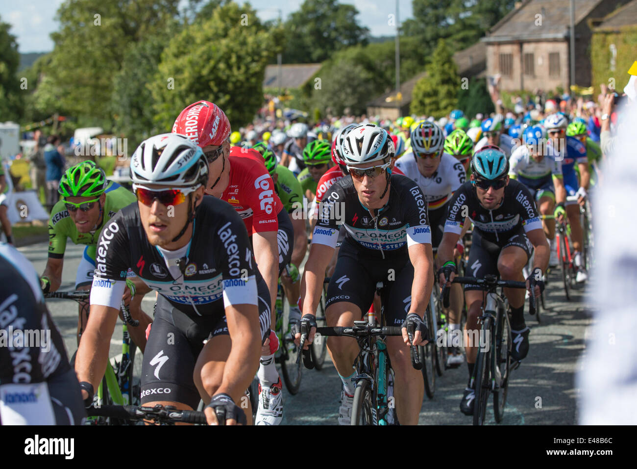 Harrogate, Nordyorkshire. 5. Juli 2014. Ein dicht gepackten Hauptfeld betritt Yorkshire Dorf von Killinghall, 3 Meilen vom den ersten Tag beenden in Harrogate. Copyright Ian Wray/Alamy Live-Nachrichten Stockfoto