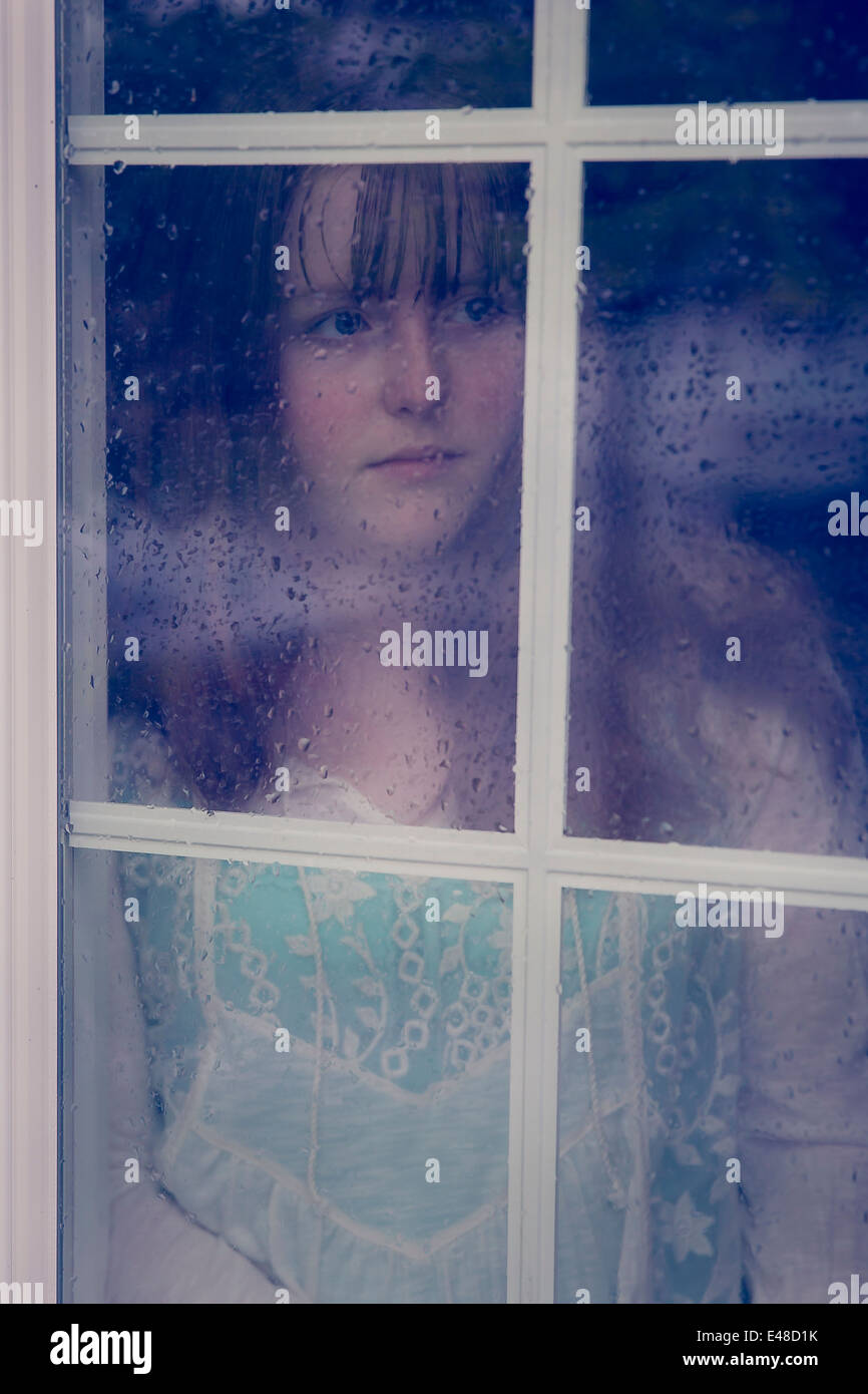 Nachdenklich Mädchen Blick durch Fenster Stockfoto