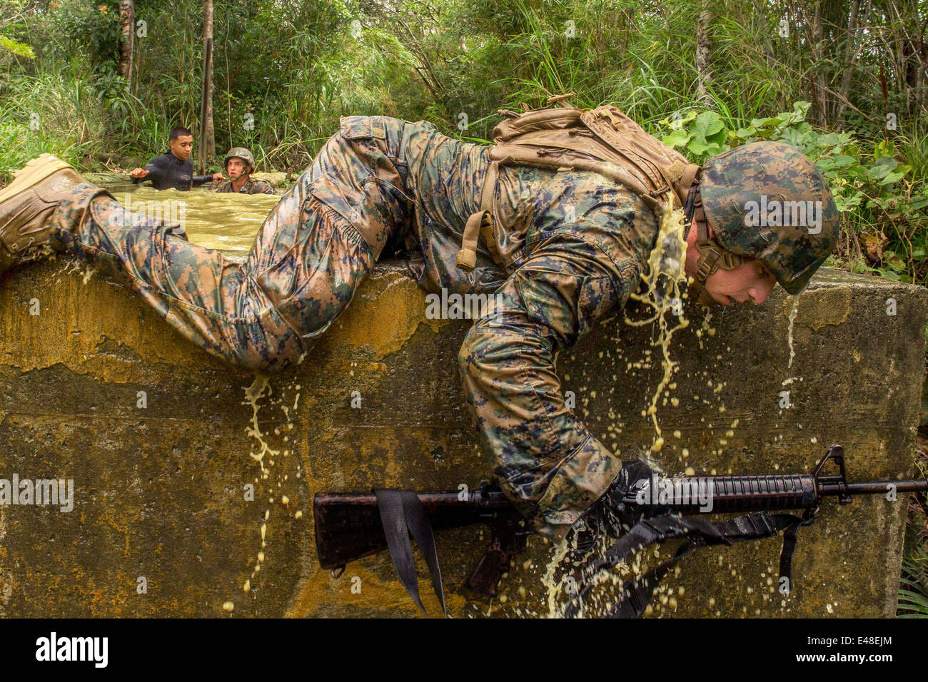 Ein US-Marine kriecht über eine Steinmauer im Verlauf Dschungel Ausdauer bei der Jungle Warfare Training Center am Camp Gonsalves 20. Juni 2014 in Okinawa, Japan. Stockfoto