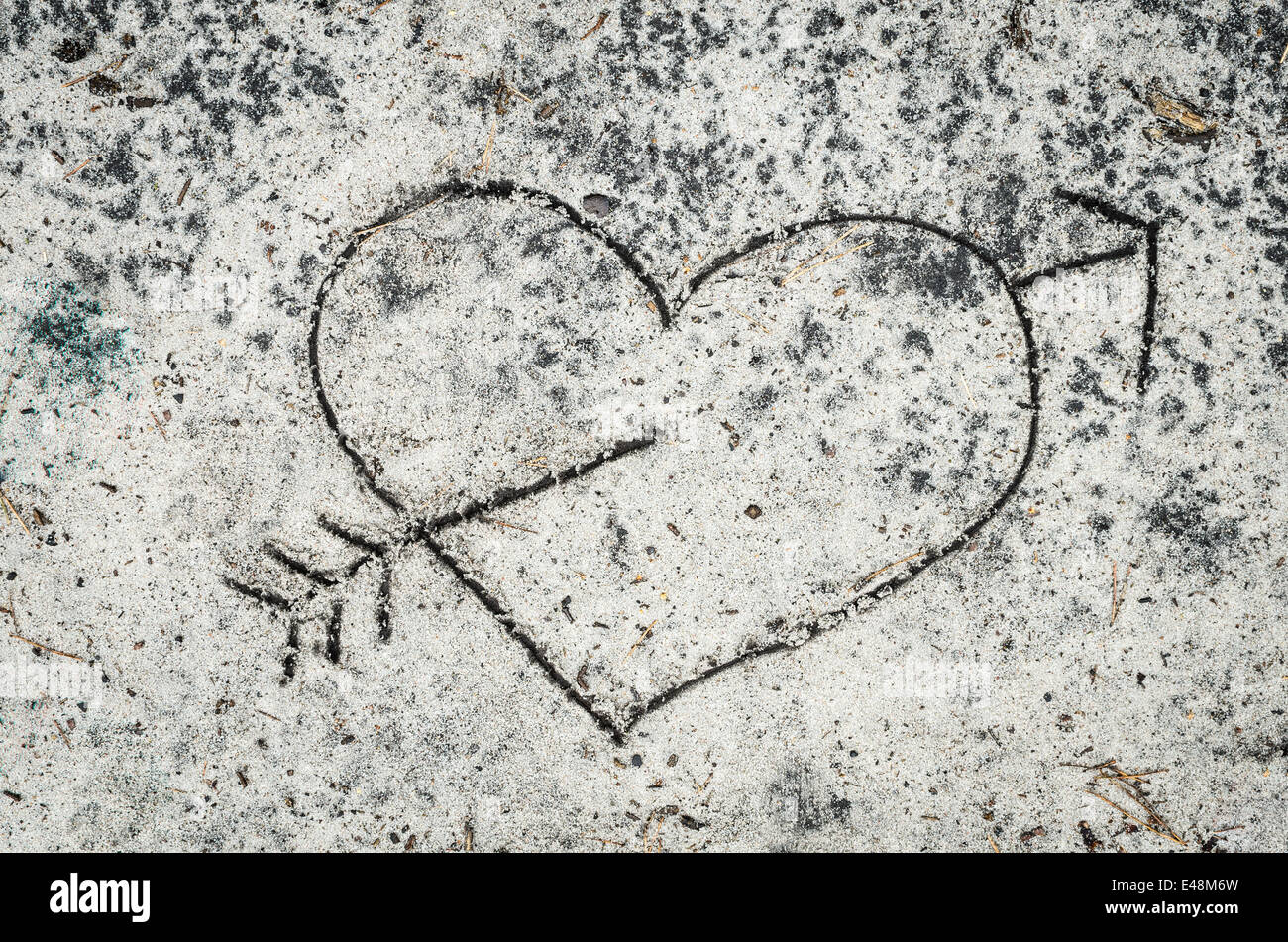 Closeup, Herzschild durchbohrt vom Pfeil auf Sand Hintergrund Stockfoto