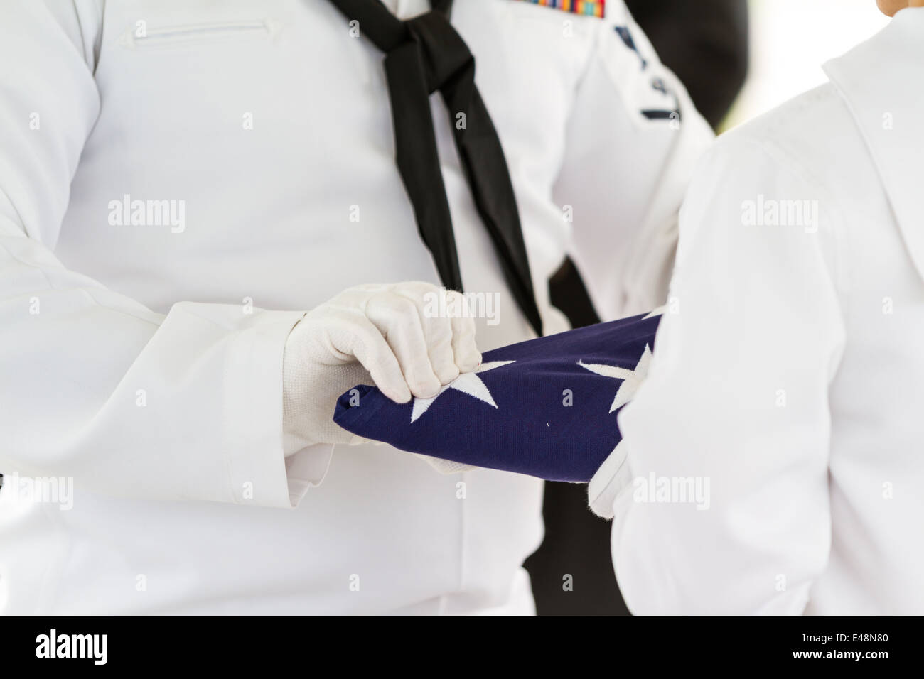 aktiven Marine Vertreter Faltung ein Flag im Rahmen einer Zeremonie für ein Veteranen-Begräbnis Stockfoto