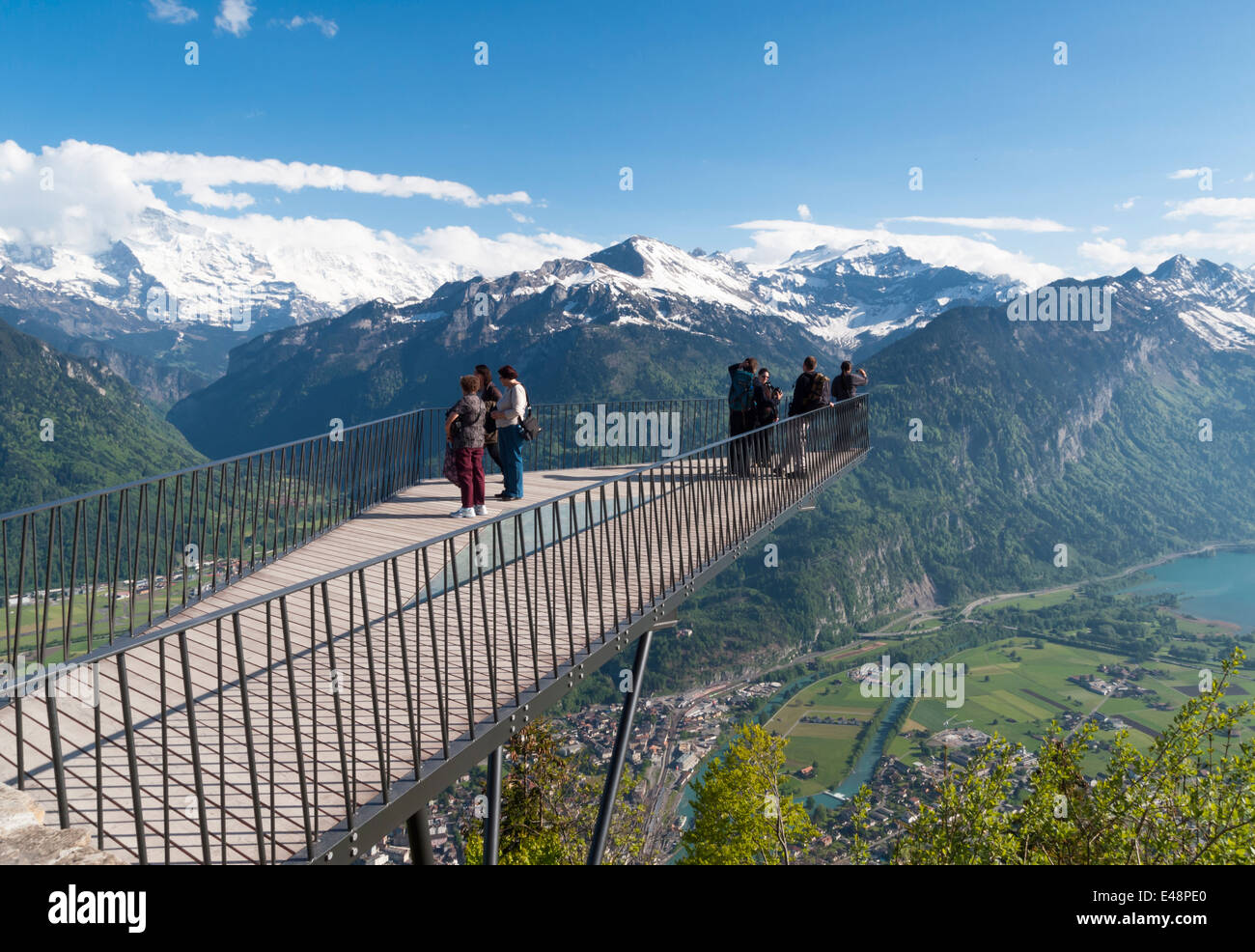 Touristen sind auf einem Aussichtspunkt am Harder Kulm, einen Blick auf die Stadt Interlaken, Thuner See und die Schweizer Alpen sammeln. Stockfoto