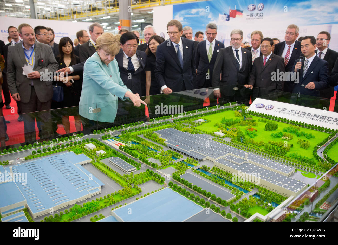 Deutsche Bundeskanzlerin Angela Merkel (L), Mitglied des Vorstands der Volkswagen, Jochem Heizmann (3. L) und Ulrich Grillo (C), Vorsitzender des Vorstands der Grillo-Werke AG und Präsident des von der Föderation der deutschen Industrie (BDI), hören Sie Xu Jianyi (erste Reihe C, L), der Präsident von First Automotive Works, als er erklärt die Produktionsstätte bei FAW-VW Werk in Chengdu , China. 6. Juli 2014. Angela Merkel wird mit einer hochrangigen Wirtschaftsdelegation begleitet und wird in China bis 8. Juli 2014 bleiben. Merkel ist auch geplant, Bejing während ihrer Reise besuchen. Foto: Kay Nietfeld Stockfoto