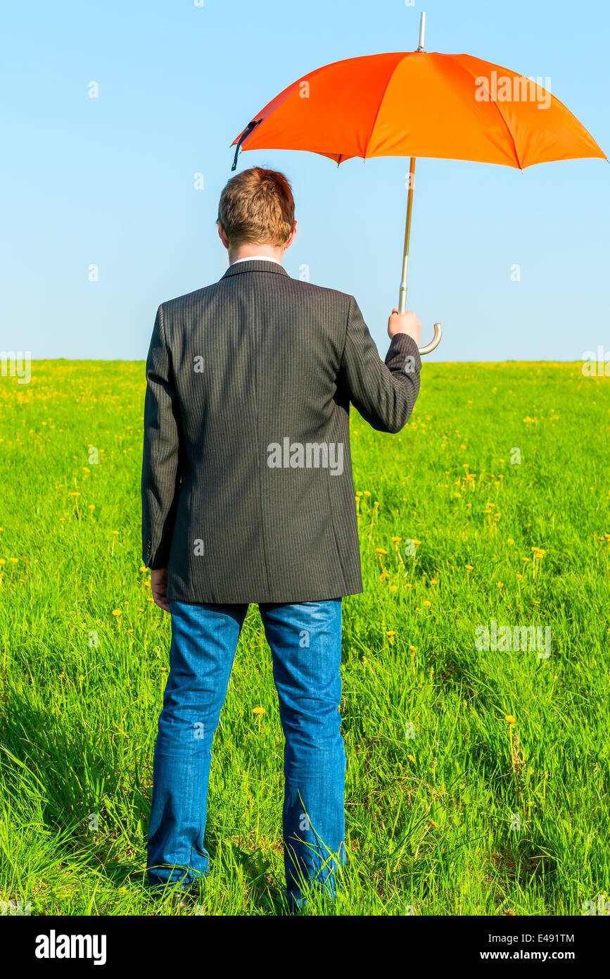 konzeptionelle Foto männlich in der Natur mit einem Regenschirm Stockfoto
