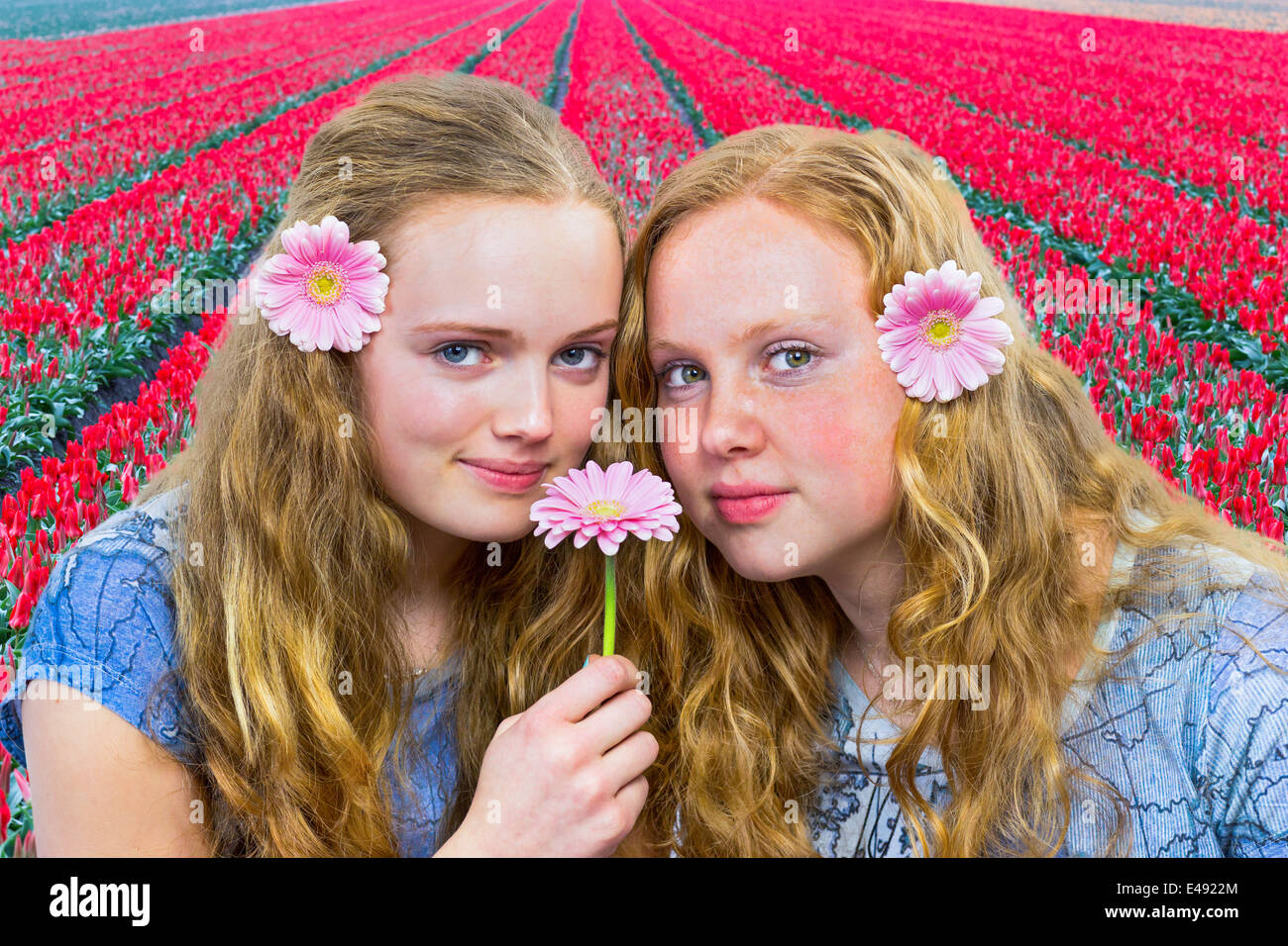 Zwei Mädchen im Teenageralter vor roten Tulpen Feld Stockfoto