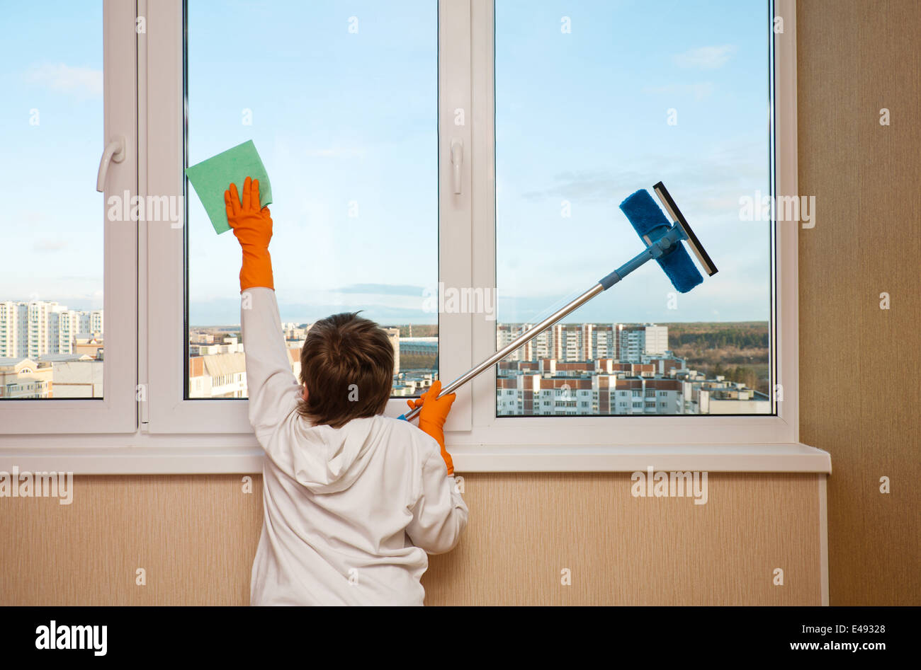 junge Kind ein waschen Fenster Lappen Handschuhe, die Arbeit im Haushalt Hilfe Helfer 9 Jahr Appartementhaus home sauber Reinigung reinigt gereinigt allgemeine cau Stockfoto