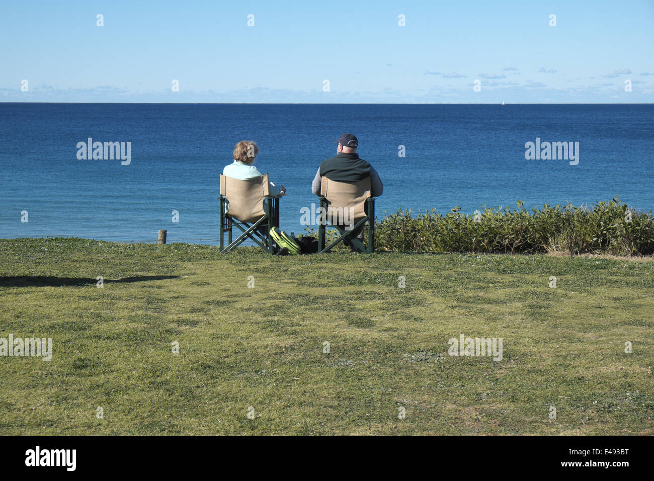 Ältere und Rentner, die am Meer sitzen und die australische Küste am Palm Beach, sydney, nsw, Australien genießen Stockfoto