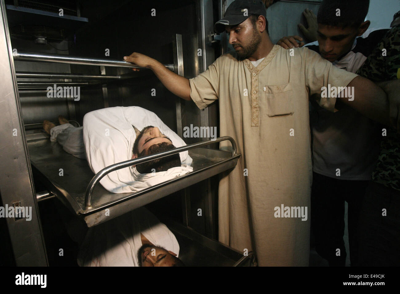Rafah, Gaza-Streifen, Palästinensische Gebiete. 7. Juli 2014. Menschen trauern um die Leichen von zwei palästinensische militante an einem Krankenhaus Leichenschauhaus in Rafah im südlichen Gazastreifen 7. Juli 2014. Israelische Luftangriffe getötet mindestens sechs Hamas-Kämpfer Montag früh, sagte der islamistischen Gruppe bewaffneten Flügel. Israelische militärische Behörden bestätigten die Streiks, sagen sie '' reagierte auf Raketenangriffe gegen Süden Israels '' 9 '' Terror'' targeting-sites und verborgen Raketenwerfer Credit: Eyad Al Baba/APA Bilder/ZUMA Draht/Alamy Live News Stockfoto
