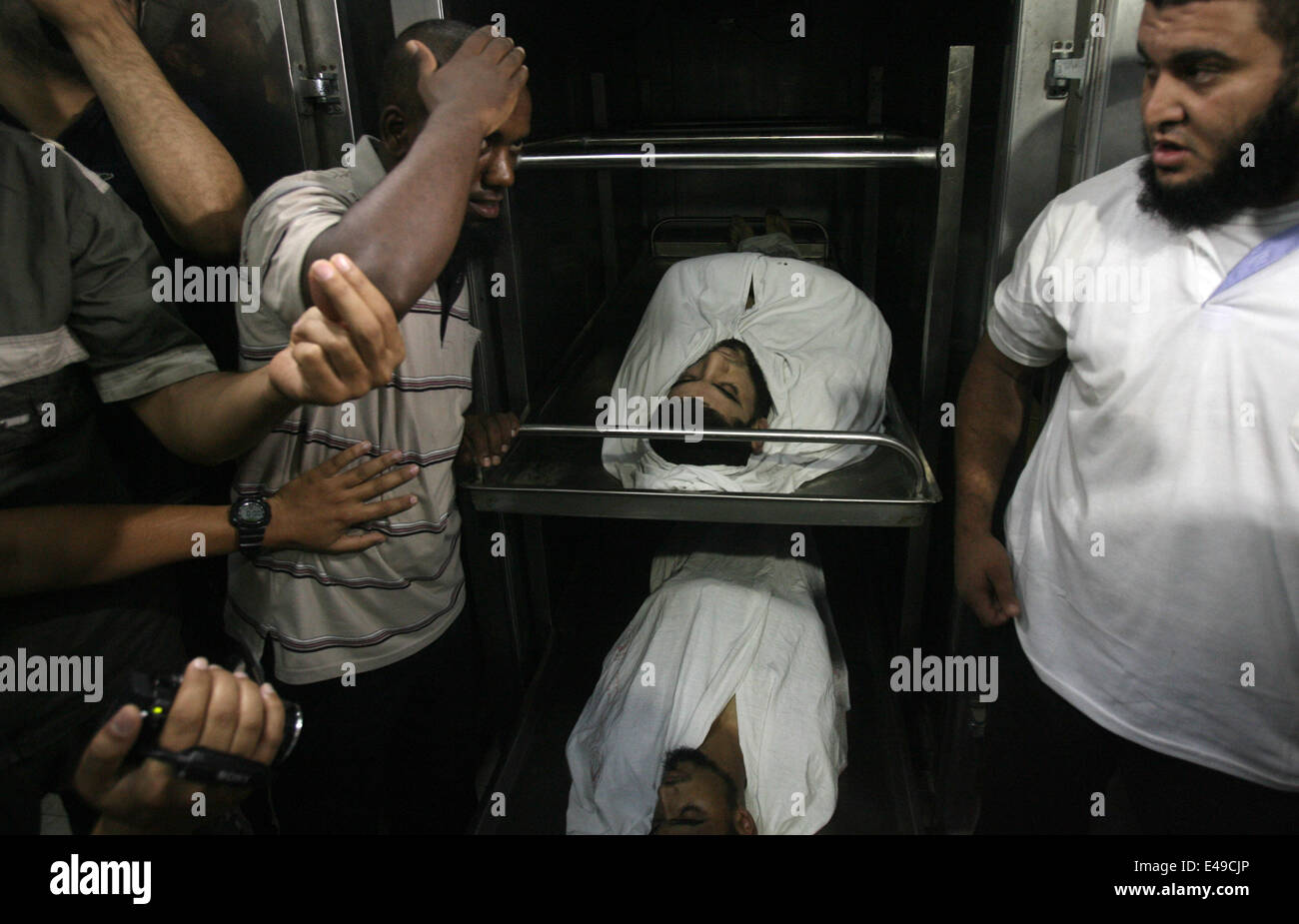 Rafah, Gaza-Streifen, Palästinensische Gebiete. 7. Juli 2014. Menschen trauern um die Leichen von zwei palästinensische militante an einem Krankenhaus Leichenschauhaus in Rafah im südlichen Gazastreifen 7. Juli 2014. Israelische Luftangriffe getötet mindestens sechs Hamas-Kämpfer Montag früh, sagte der islamistischen Gruppe bewaffneten Flügel. Israelische militärische Behörden bestätigten die Streiks, sagen sie '' reagierte auf Raketenangriffe gegen Süden Israels '' 9 '' Terror'' targeting-sites und verborgen Raketenwerfer Credit: Eyad Al Baba/APA Bilder/ZUMA Draht/Alamy Live News Stockfoto