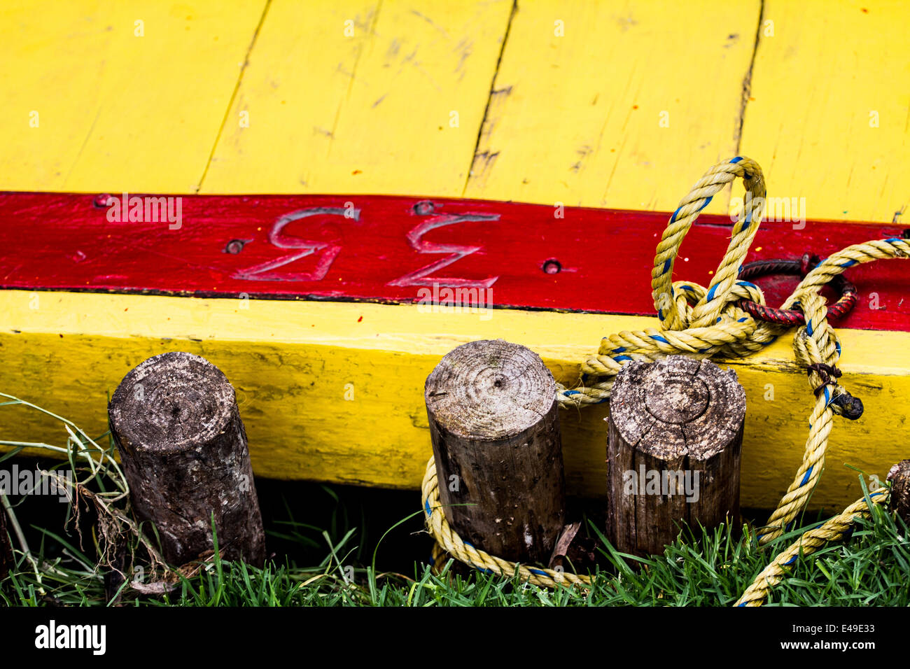 Hölzerne Floß gemacht von gelb und rot, die hölzerne Planken am Ufer geparkt Stockfoto