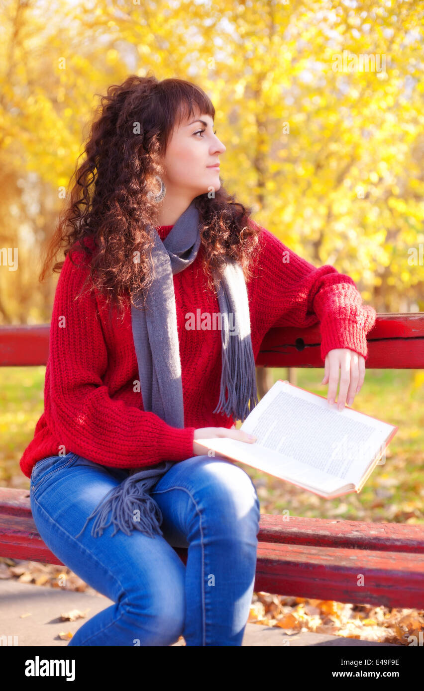 Mädchen mit Buch im sonnigen Herbst park Stockfoto