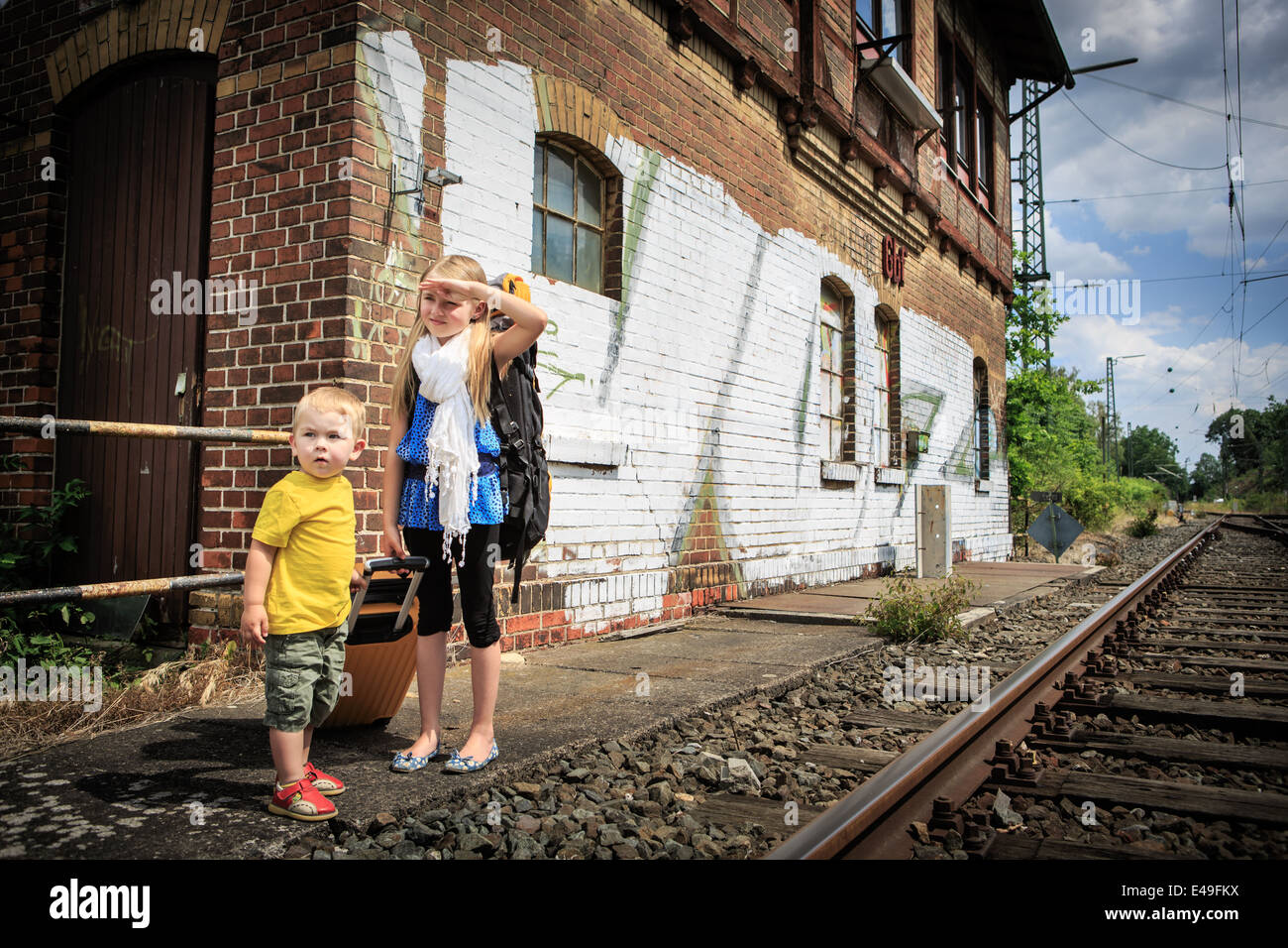 Kinder warten auf den Zug auf einem Bahnhof Stockfoto