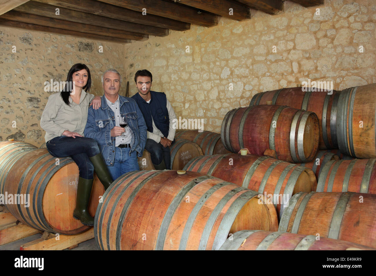 drei Menschen, die trinken Wein im Keller Stockfoto