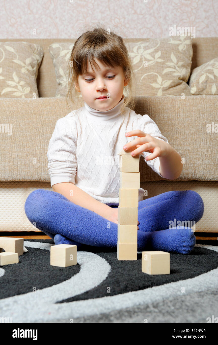 Das kleine Mädchen spielt Holzspielzeug Würfel Stockfoto