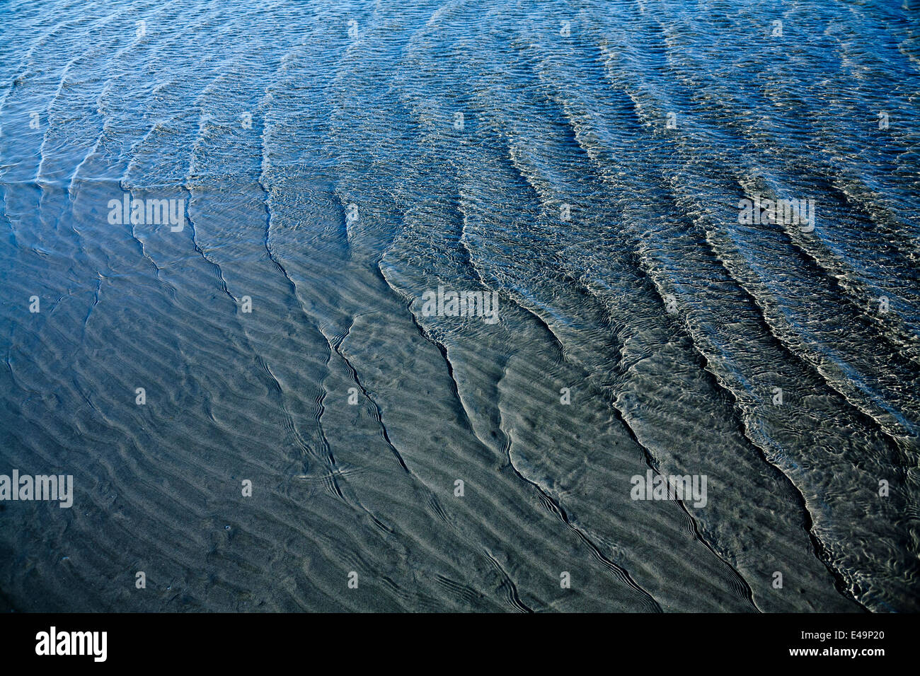 Wellenmuster auf Sandboden und Wellen Stockfoto