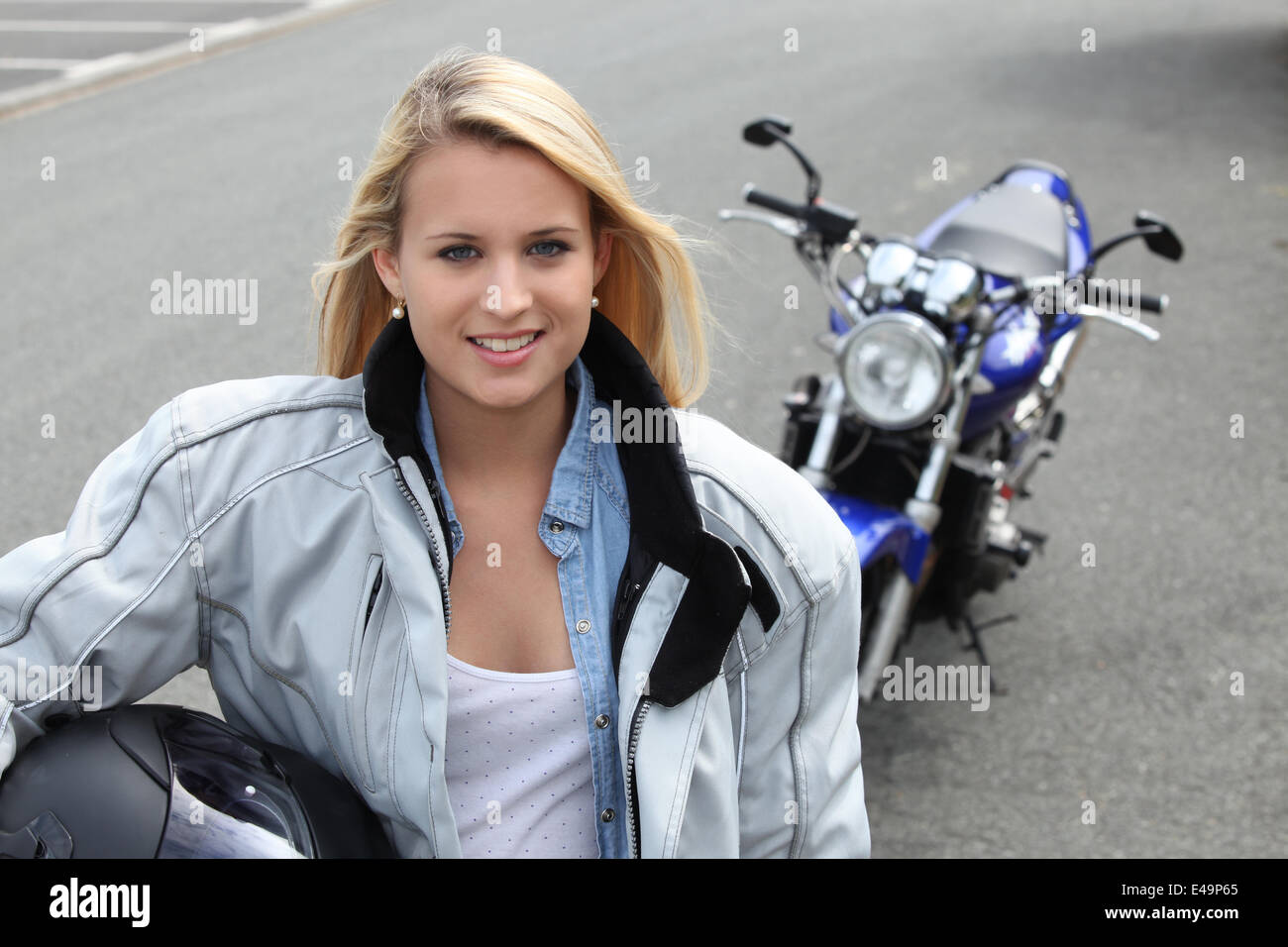 Blonde Frau stand mit dem Motorrad Stockfoto
