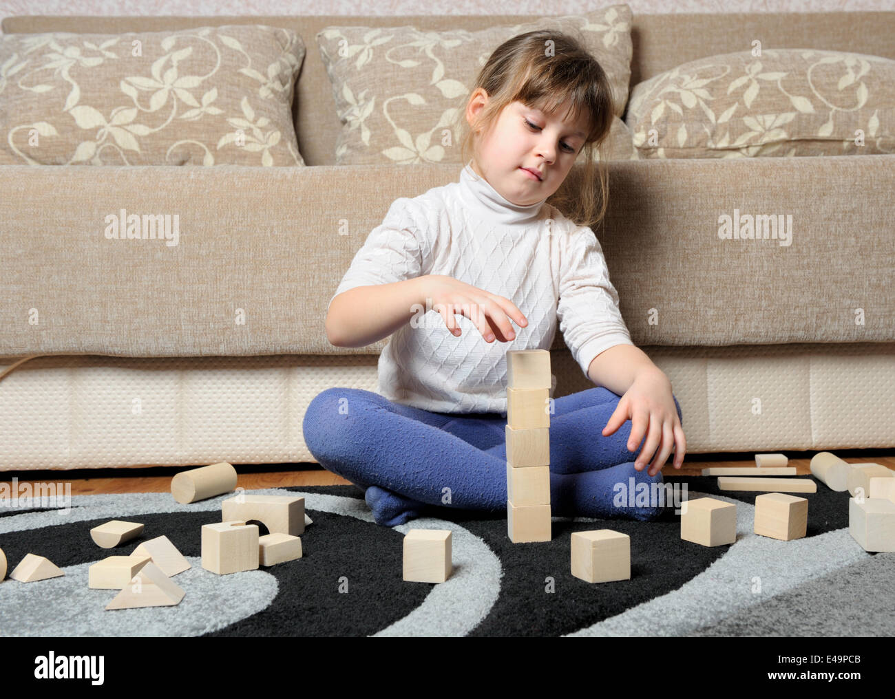 Das kleine Mädchen spielt Holzspielzeug Würfel Stockfoto
