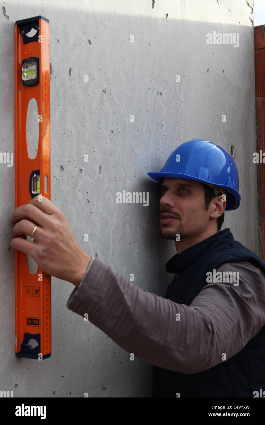 Handwerker, die die Messungen mit einer Ebene Stockfoto