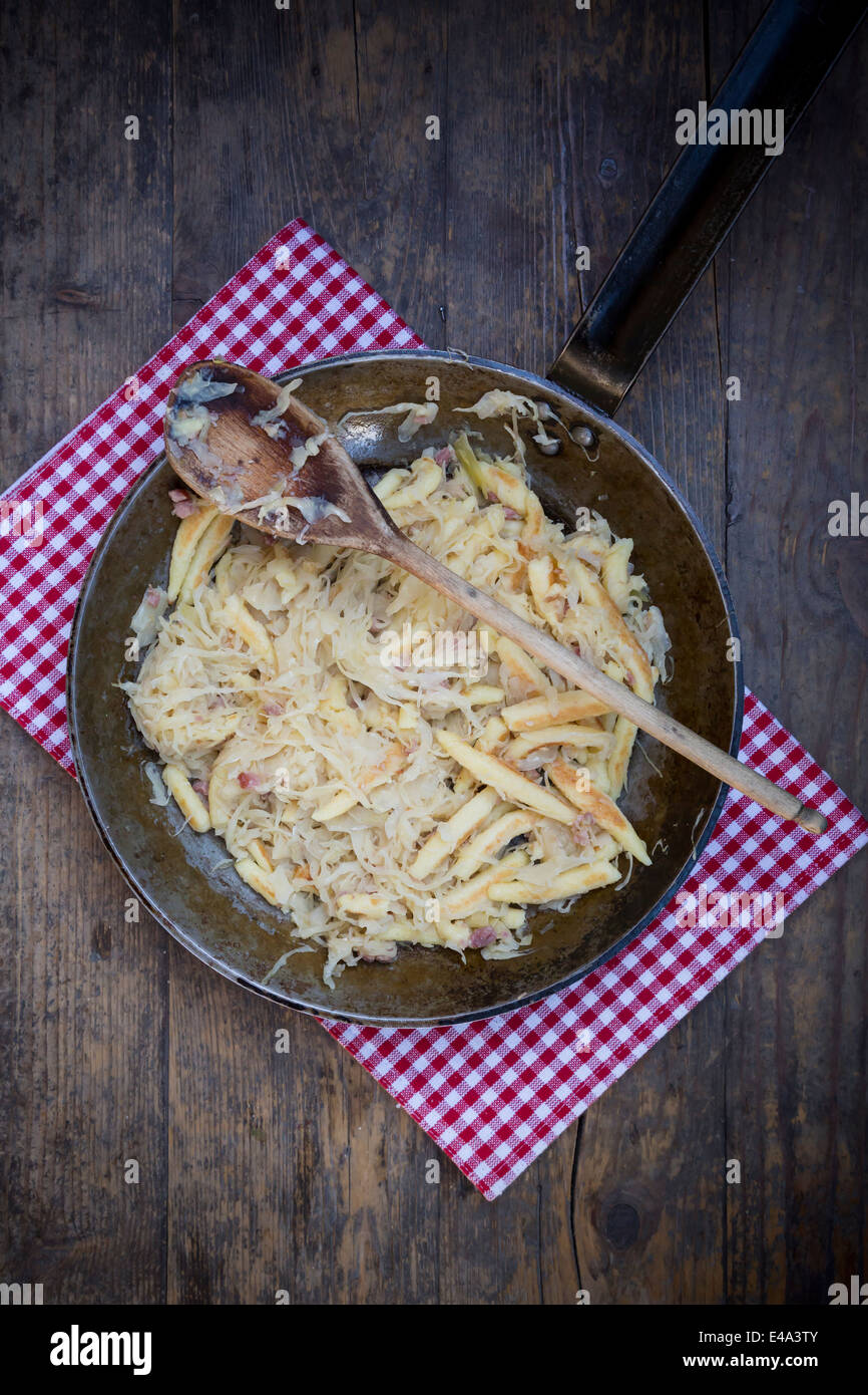 Pfanne von fingerförmige Kartoffelknödel mit Sauerkraut und Speck auf Tuch Stockfoto