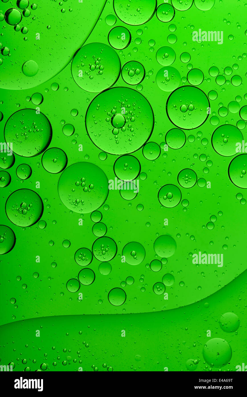 Öl und Wasser vor grünem Hintergrund Stockfoto