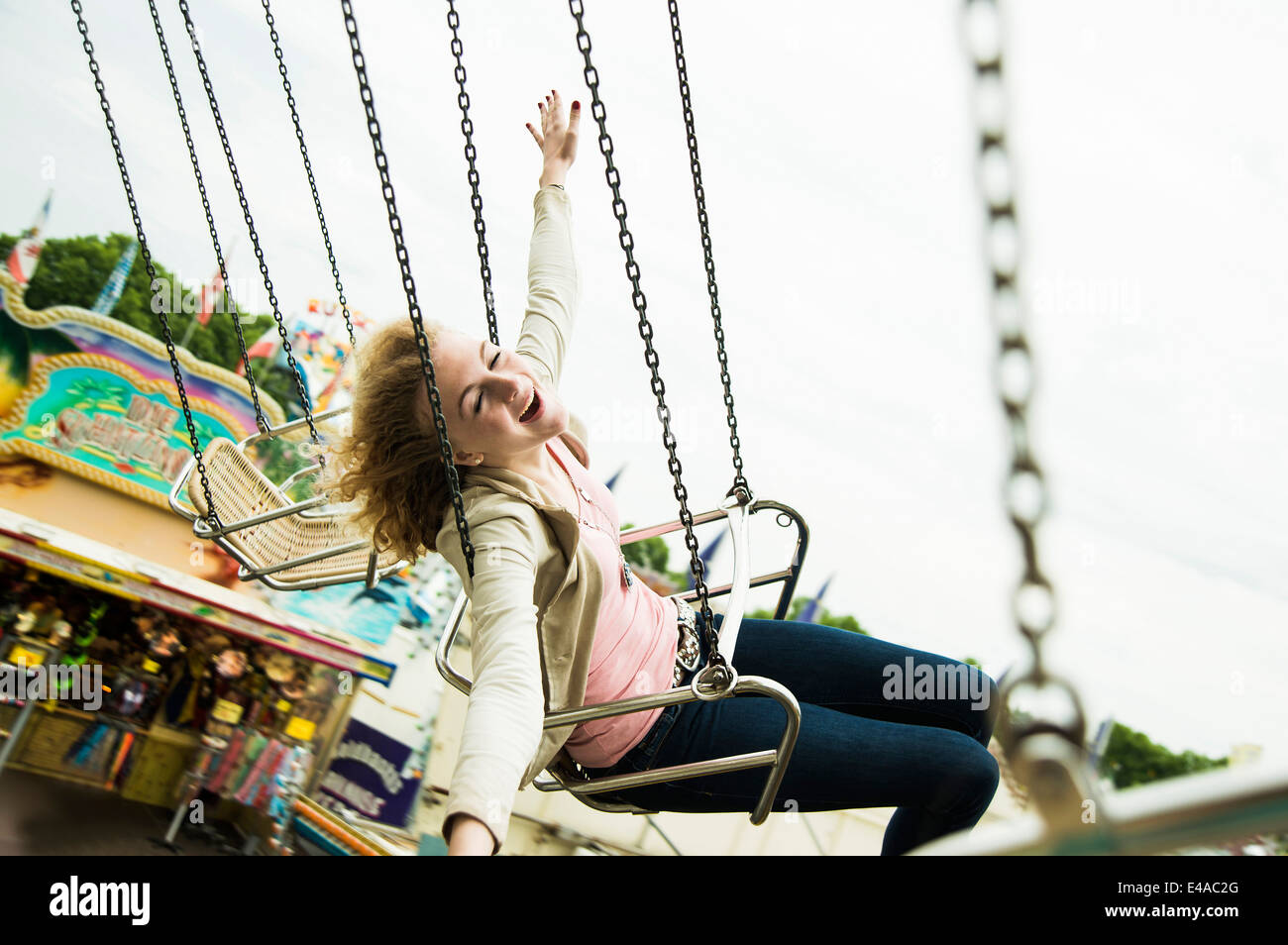 Glücklich Eenage Mädchen auf Kettenkarussell auf der Kirmes Stockfoto