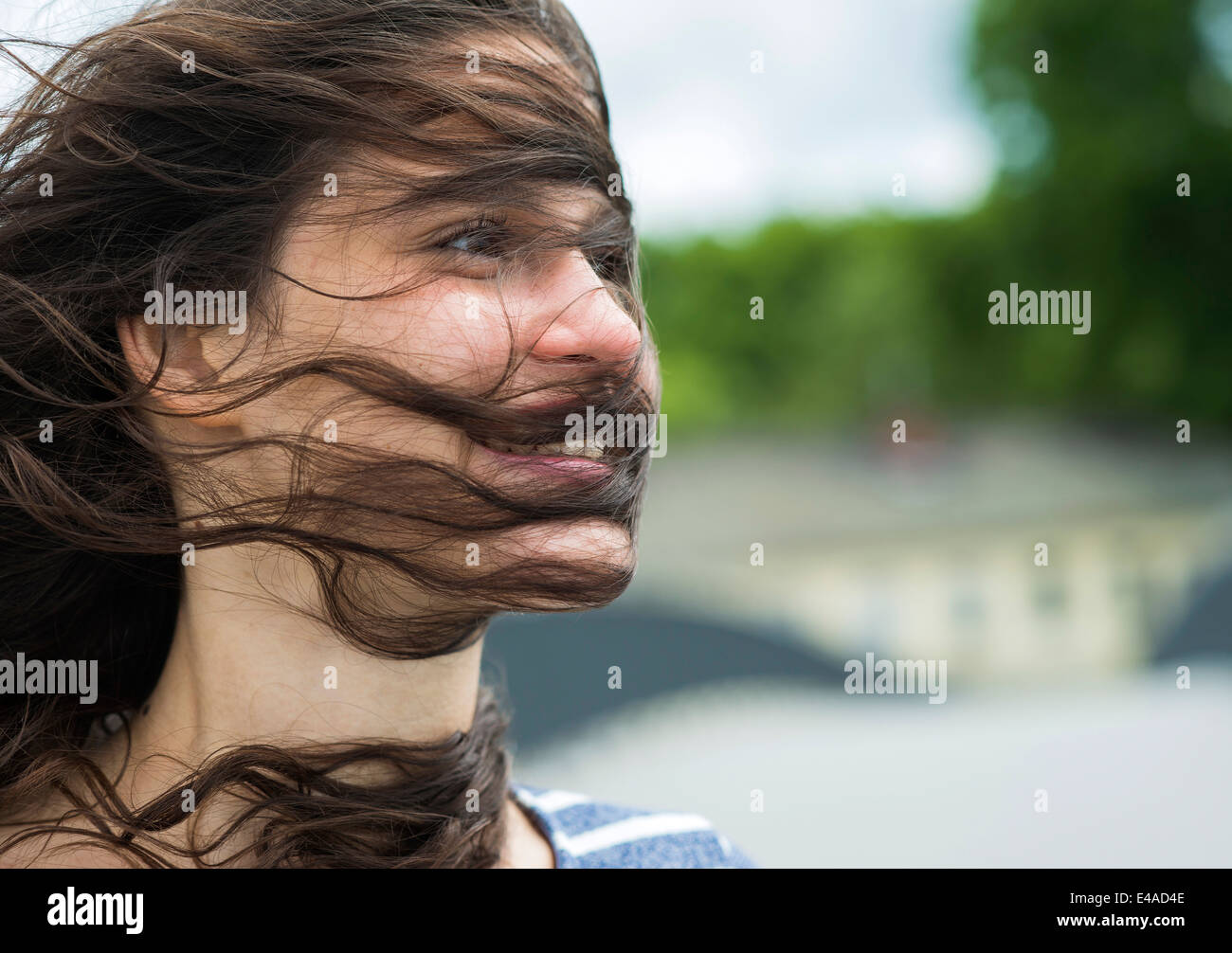 Porträt der lächelnde junge Frau mit Haarsträhnen ins Gesicht Stockfoto