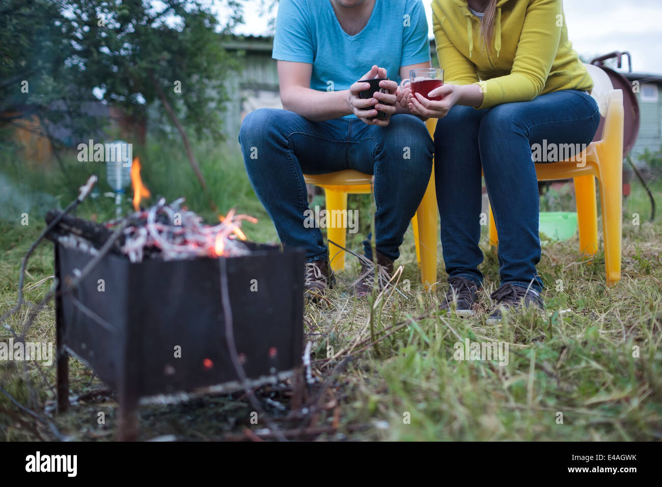 Paar mit Teetassen in Händen in der Nähe von der Schwelbrand Stockfoto