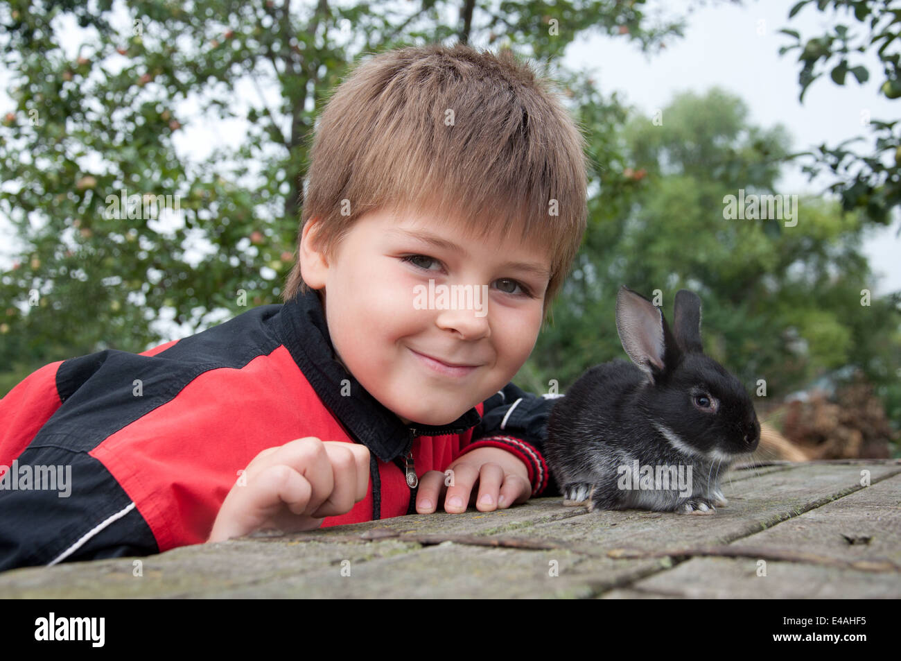 junge Kind Kaninchen tierische Gartenvilla Natur spielen 7 8 Jahre Zuchthof Dorf Familienleben, die ländliche schöne flauschige Ohren Fell Haut su Stockfoto