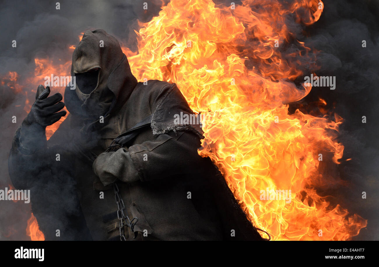 Ein Stuntman in Brand führt quer durch die sogenannte Vulkan Arena während einer Stuntshow im Studio Babelsberg in Potsdam, Deutschland, 7. Juli 2014. Die Stunt-Arena wurde vor 15 Jahren gebaut und wurde bis zu 3.333 Shows mit mehr als 5 Millionen Besucher seit dieser Zeit zeigt. Foto: Ralf Hirschberger/dpa Stockfoto